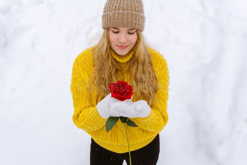 Ragazza con una rosa sui precedenti di neve fotografie stock Ragazza con una rosa sui precedenti di neve fotografie stock