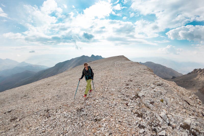 Ragazza con uno zaino in montagna fotografia stock