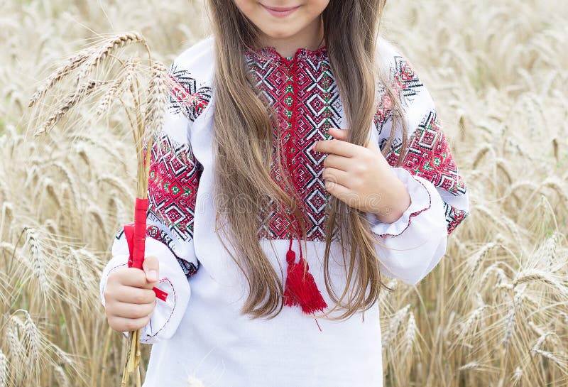 Ragazza in costume nazionale con ricamo che tiene un mazzo di grano fotografia stock Ragazza in costume nazionale con ricamo che tiene un mazzo di grano fotografia stock