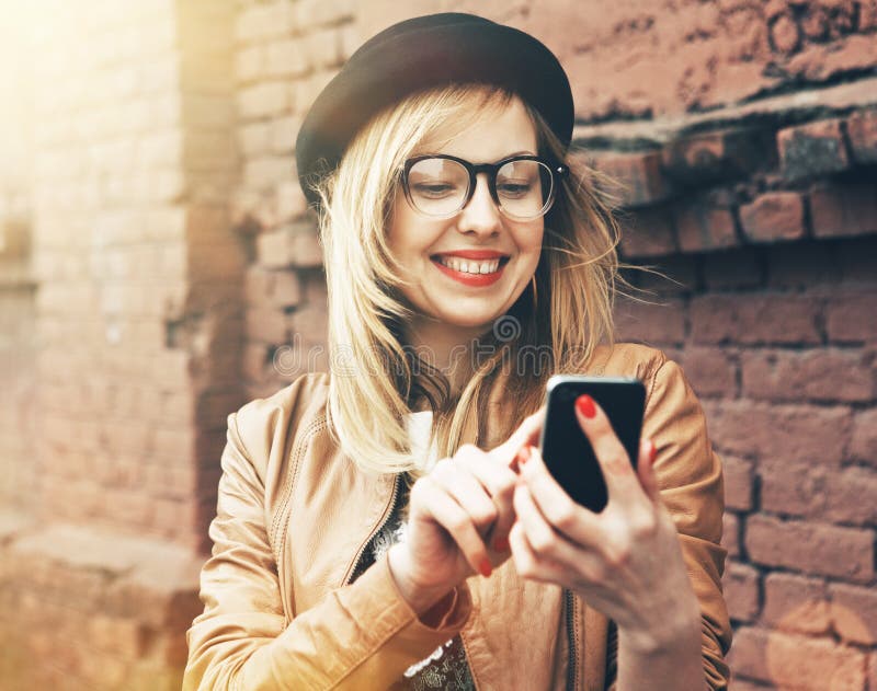 Ragazza dei pantaloni a vita bassa che per mezzo del telefono fotografie stock libere da diritti Ragazza dei pantaloni a vita bassa che per mezzo del telefono fotografie stock libere da diritti