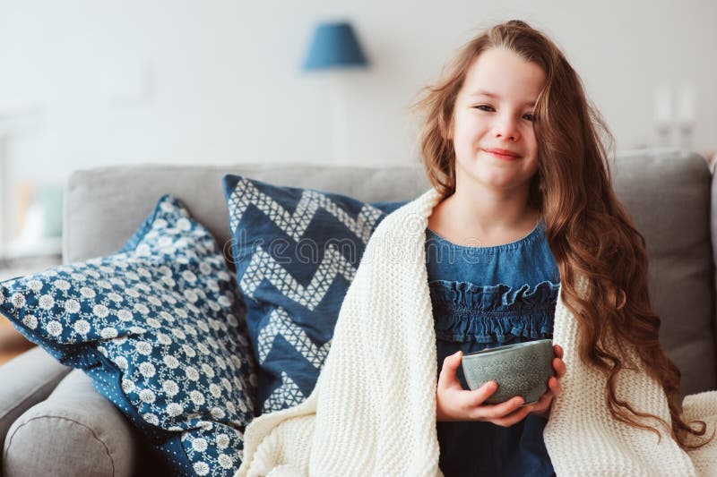 ragazza del bambino che beve tè caldo per recuperare da influenza fotografie stock ragazza del bambino che beve tè caldo per recuperare da influenza fotografie stock