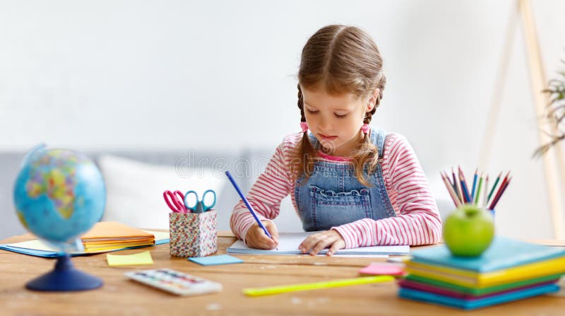 Ragazza del bambino che fa scrittura e la lettura di compito a casa immagini stock