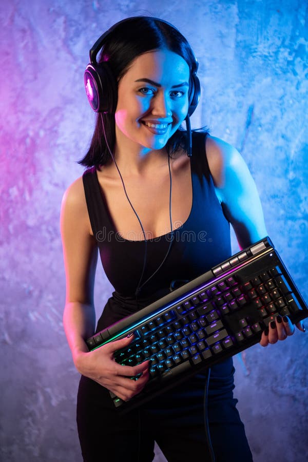 Ragazza del Gamer che gioca con il computer a casa Giovane posa femminile con la tastiera di computer immagini stock Ragazza del Gamer che gioca con il computer a casa Giovane posa femminile con la tastiera di computer immagini stock
