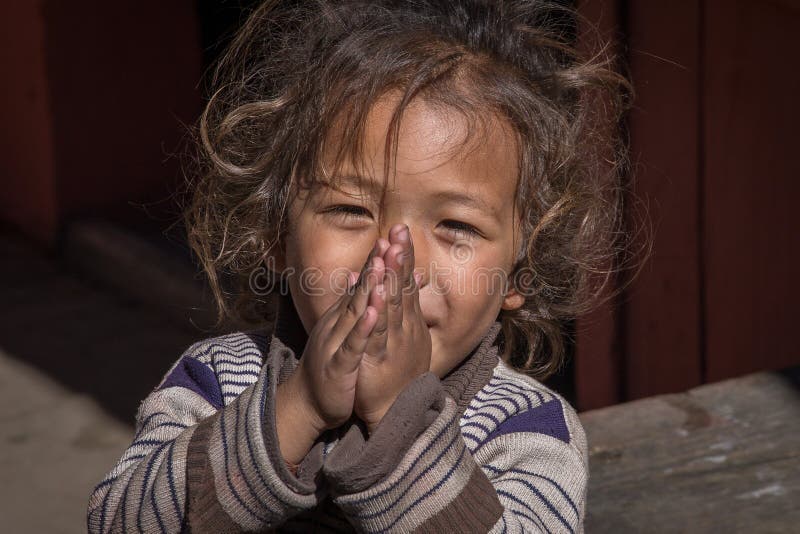 Ritratto di una giovane ragazza con le mani giunte in una strada, Nepal. Primo piano fotografia stock
