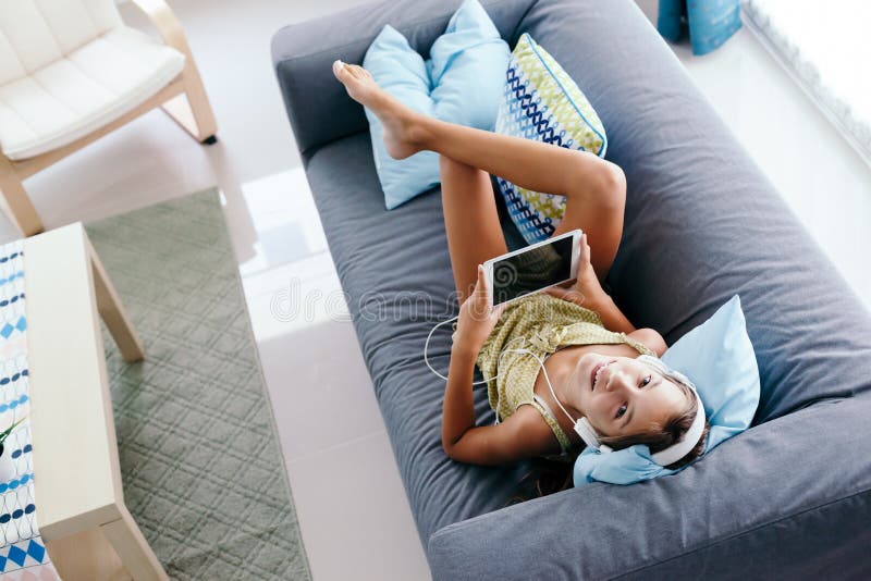 Ragazza del Tween che si rilassa sullo strato a casa fotografia stock Ragazza del Tween che si rilassa sullo strato a casa fotografia stock