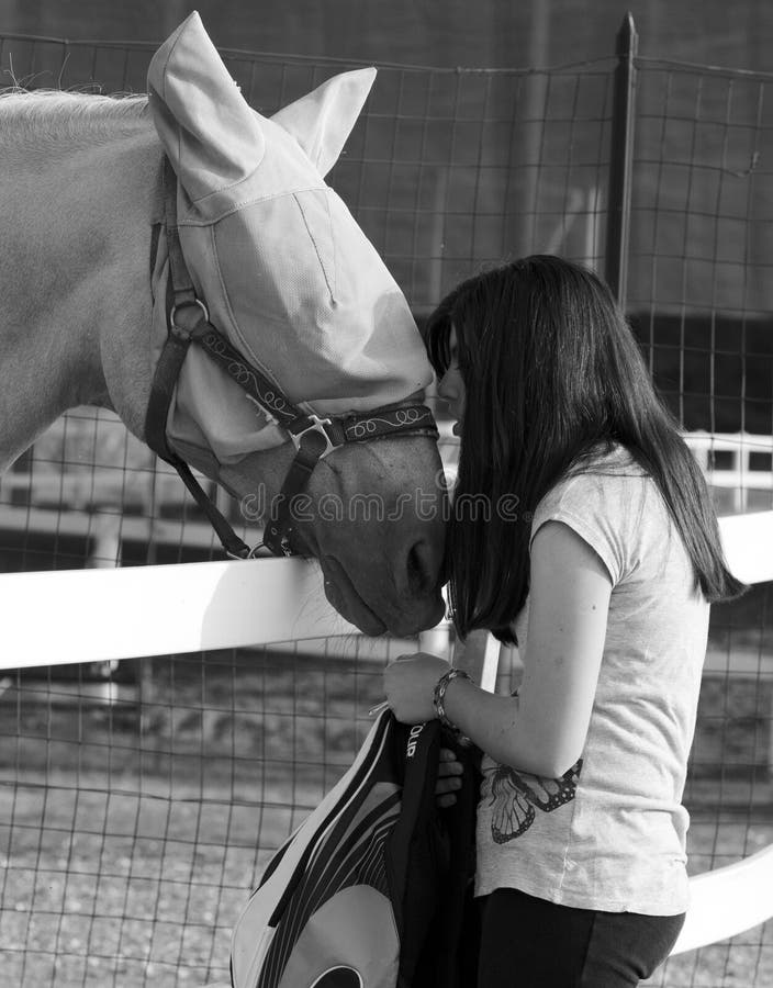 Ragazza dell'adolescente che bacia allegro qui cavallo fotografia stock libera da diritti Ragazza dell'adolescente che bacia allegro qui cavallo fotografia stock libera da diritti