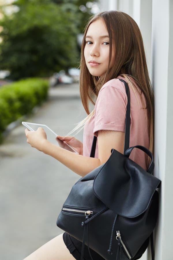 Ragazza della scuola che usa un tablet computer Studente vicino all'università immagine stock Ragazza della scuola che usa un tablet computer Studente vicino all'università immagine stock