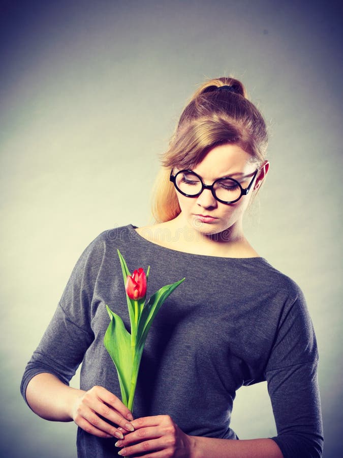 Ragazza deludente di ribaltamento con il singolo tulipano fotografia stock libera da diritti Ragazza deludente di ribaltamento con il singolo tulipano fotografia stock libera da diritti