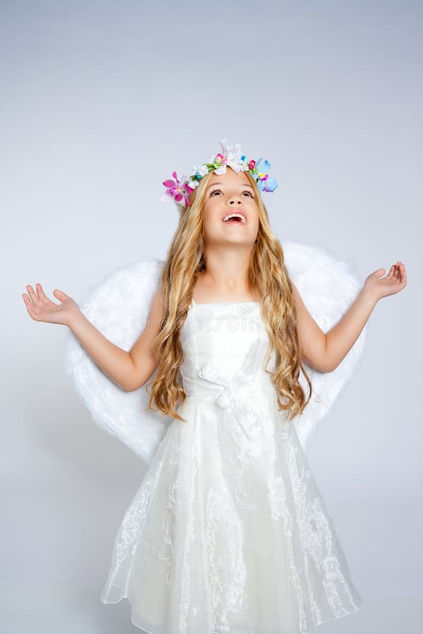 Ragazza di angelo dei bambini che osserva in su cielo con le mani aperte fotografia stock
