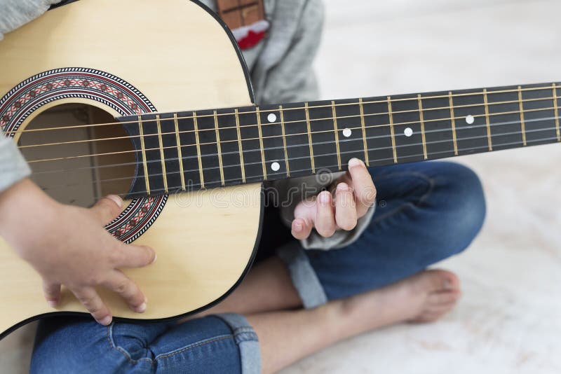 Ragazza di 9 anni che impara giocare la chitarra fotografia stock Ragazza di 9 anni che impara giocare la chitarra fotografia stock