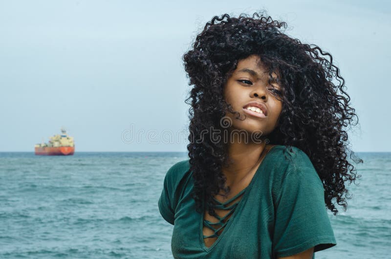 Ragazza di colore nero, capelli di risata in ruota di ferris, sedentesi godendo di un giorno di estate immagine stock Ragazza di colore nero, capelli di risata in ruota di ferris, sedentesi godendo di un giorno di estate immagine stock