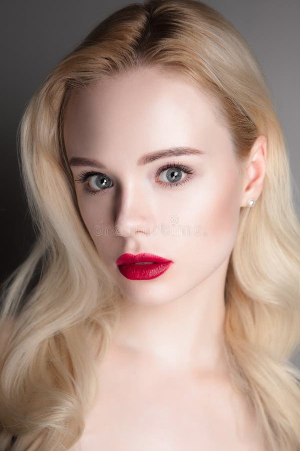 Ragazza di modello di bellezza con le labbra rosse e gli occhi azzurri di trucco perfetto che esaminano macchina fotografica Ritr immagine stock libera da diritti Ragazza di modello di bellezza con le labbra rosse e gli occhi azzurri di trucco perfetto che esaminano macchina fotografica Ritr immagine stock libera da diritti