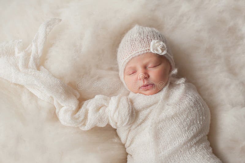 Ragazza di neonato che indossa un cofano tricottato bianco fotografie stock Ragazza di neonato che indossa un cofano tricottato bianco fotografie stock