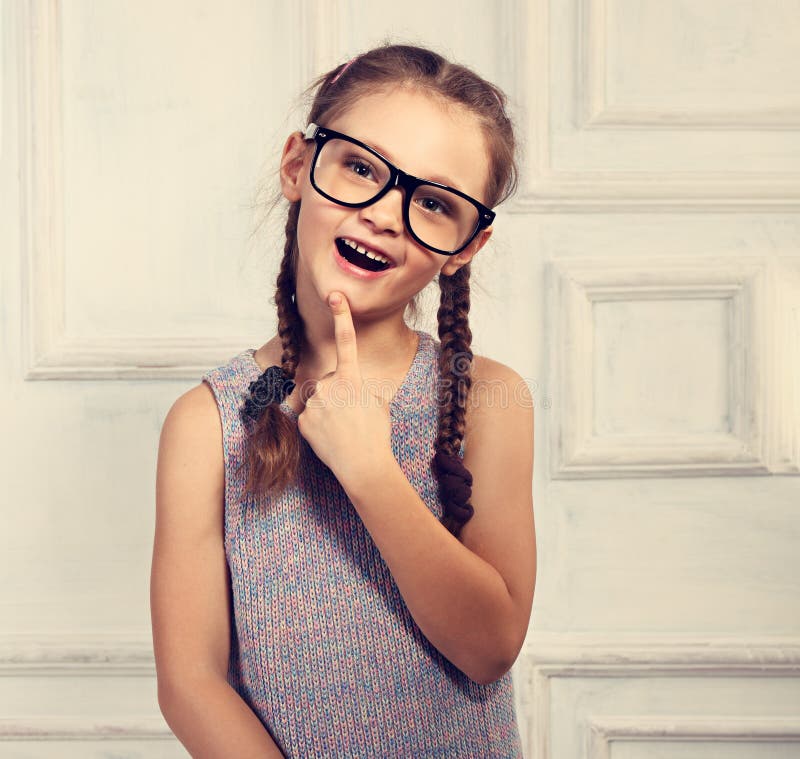Ragazza di pensiero felice del bambino in vetri di modo con il emotiona emozionante immagini stock Ragazza di pensiero felice del bambino in vetri di modo con il emotiona emozionante immagini stock