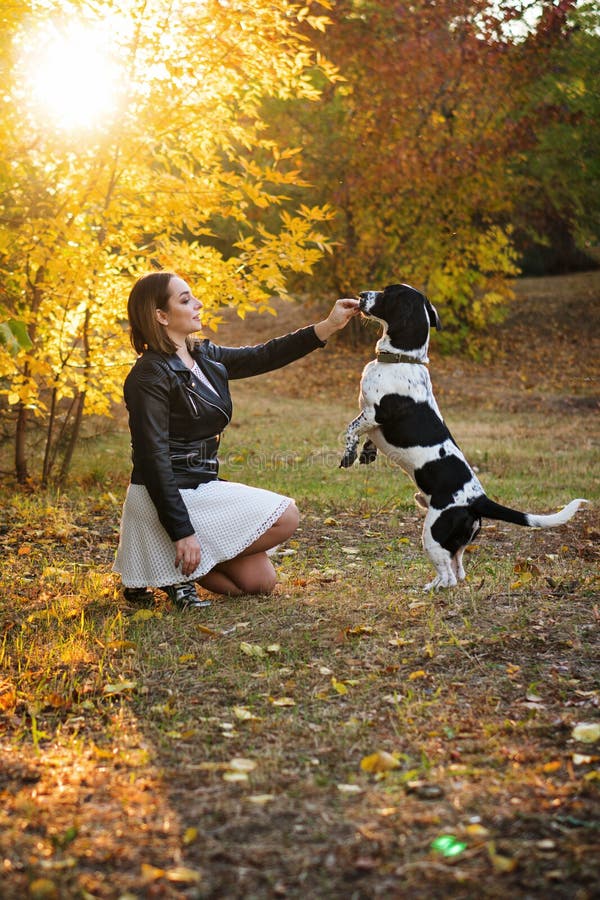 Ragazza e cane nel parco di autunno