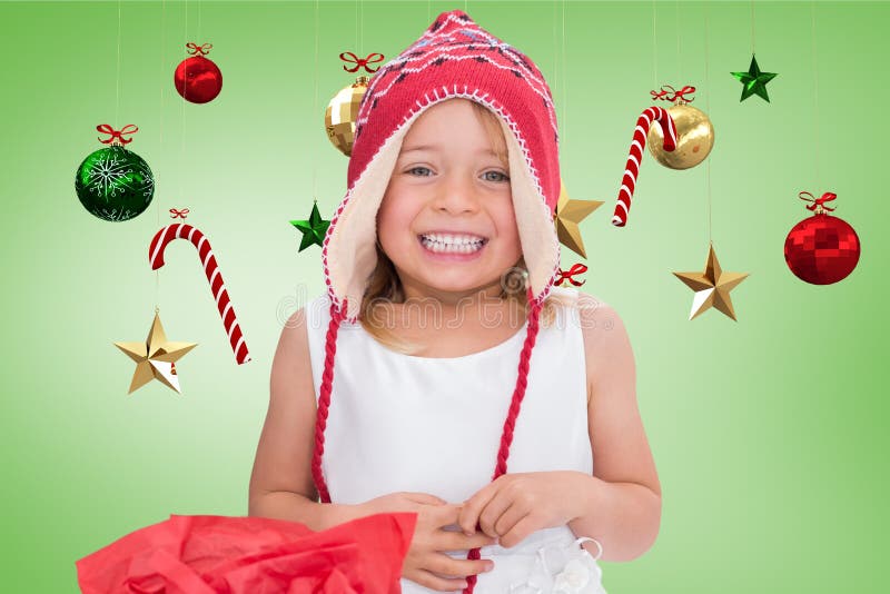 Ragazza felice in cappello di lana tricottato che sorride contro la decorazione digitalmente generata di natale fotografia stock libera da diritti Ragazza felice in cappello di lana tricottato che sorride contro la decorazione digitalmente generata di natale fotografia stock libera da diritti