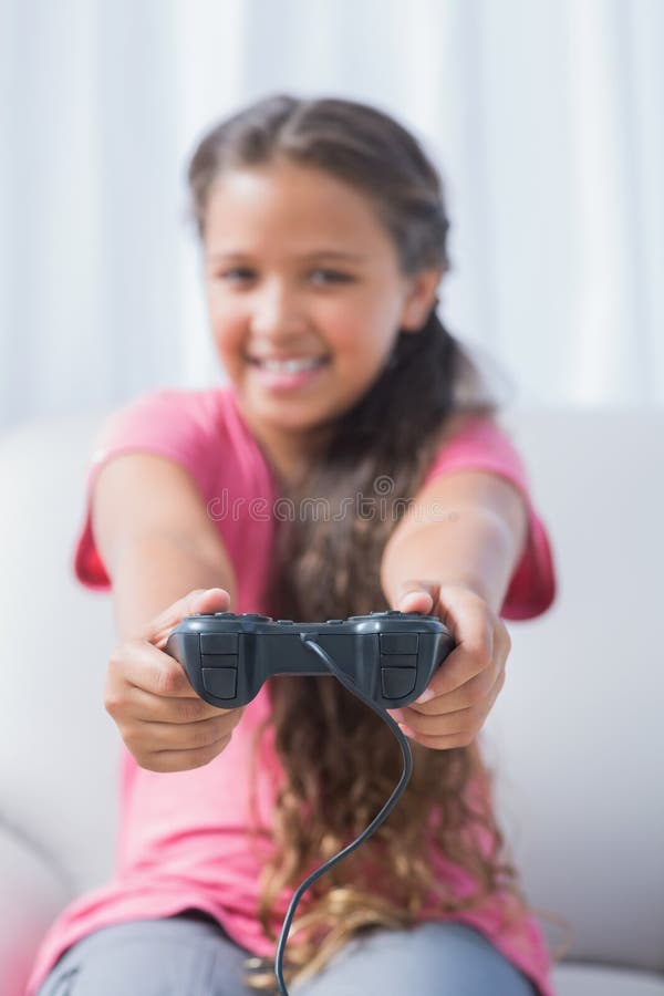 Ragazza felice che gioca video gioco sul sofà fotografie stock libere da diritti Ragazza felice che gioca video gioco sul sofà fotografie stock libere da diritti