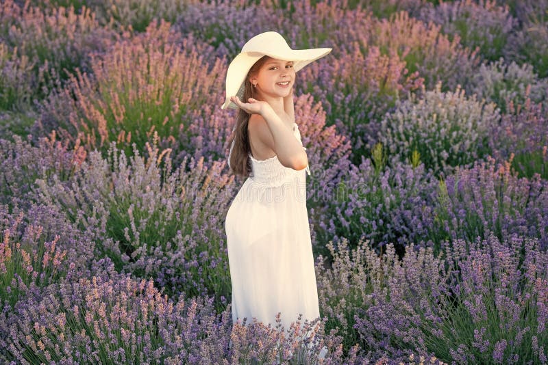 Ragazza felice che posava fiori di lavanda. bellissima ragazza nel campo di lavanda circondata da fiori. adolescente a lavender fotografie stock libere da diritti