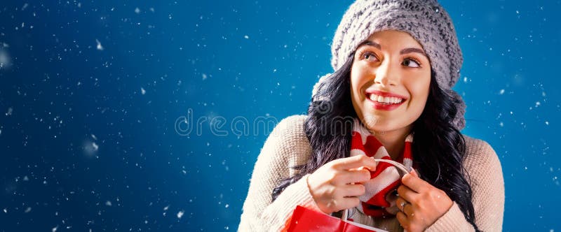 Ragazza felice che tiene una borsa della spesa in una notte di neve fotografia stock