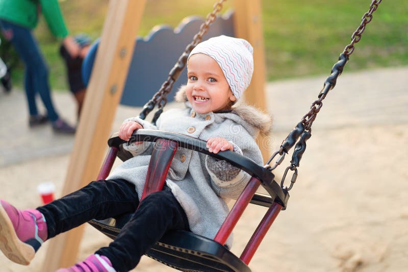 Ragazza felice del bambino su oscillazione nella caduta di tramonto Bambino che gioca in autunno sul parco naturale fotografie stock Ragazza felice del bambino su oscillazione nella caduta di tramonto Bambino che gioca in autunno sul parco naturale fotografie stock