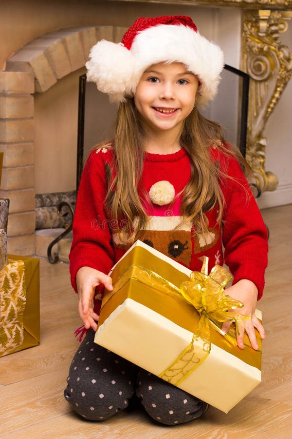 Ragazza felice sveglia in cappello rosso che tiene presente immagini stock libere da diritti Ragazza felice sveglia in cappello rosso che tiene presente immagini stock libere da diritti