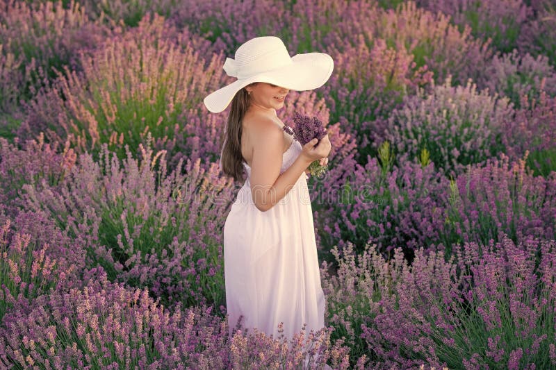 Ragazza felice vestita di bianco che cammina attraverso fiori di lavanda. bella ragazza che posava fiori di lavanda. bella ragazza immagine stock