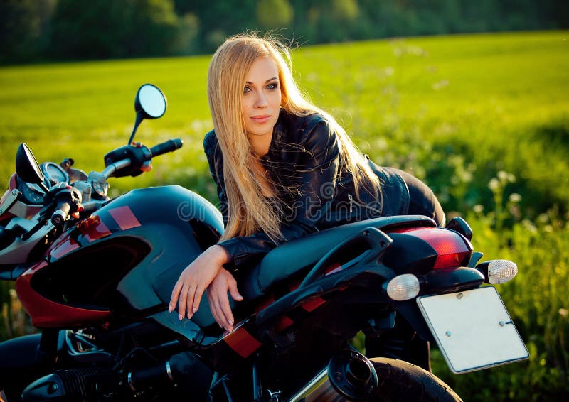 Ragazza femminile del motociclista di modo sexy Donna bionda in bomber che si siede sul motociclo su ordinazione d'annata All'ape immagine stock Ragazza femminile del motociclista di modo sexy Donna bionda in bomber che si siede sul motociclo su ordinazione d'annata All'ape immagine stock