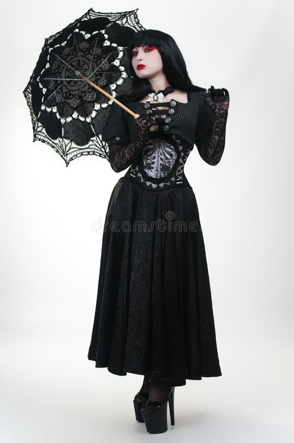 Ragazza gotica del vampiro in vestito nero con l'ombrello immagine stock Ragazza gotica del vampiro in vestito nero con l'ombrello immagine stock