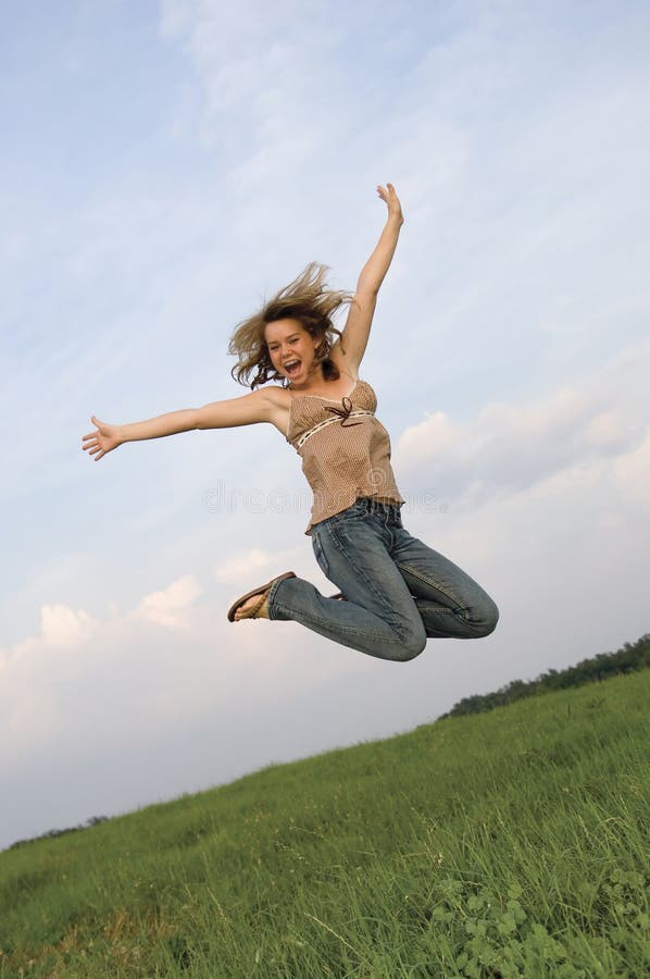 Ragazza graziosa che salta nel campo immagini stock Ragazza graziosa che salta nel campo immagini stock