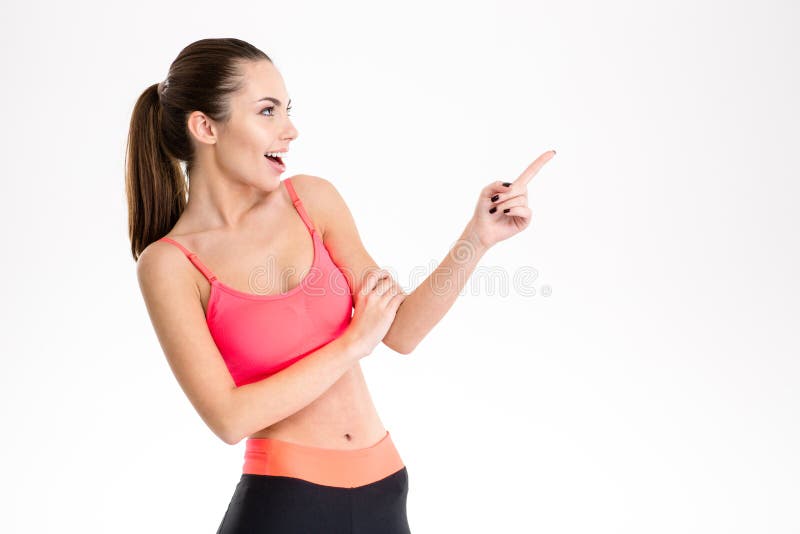 Ragazza graziosa contenta emozionante di forma fisica in sportwear che indica via fotografia stock libera da diritti Ragazza graziosa contenta emozionante di forma fisica in sportwear che indica via fotografia stock libera da diritti