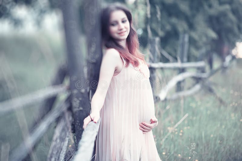 Ragazza incinta in un vestito in natura fotografia stock libera da diritti Ragazza incinta in un vestito in natura fotografia stock libera da diritti