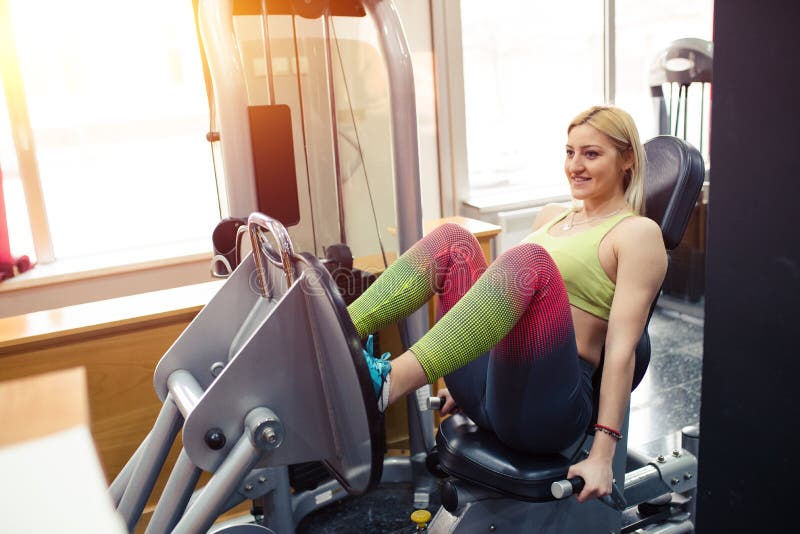 Ragazza in palestra, esercitante le sue gambe immagini stock libere da diritti Ragazza in palestra, esercitante le sue gambe immagini stock libere da diritti
