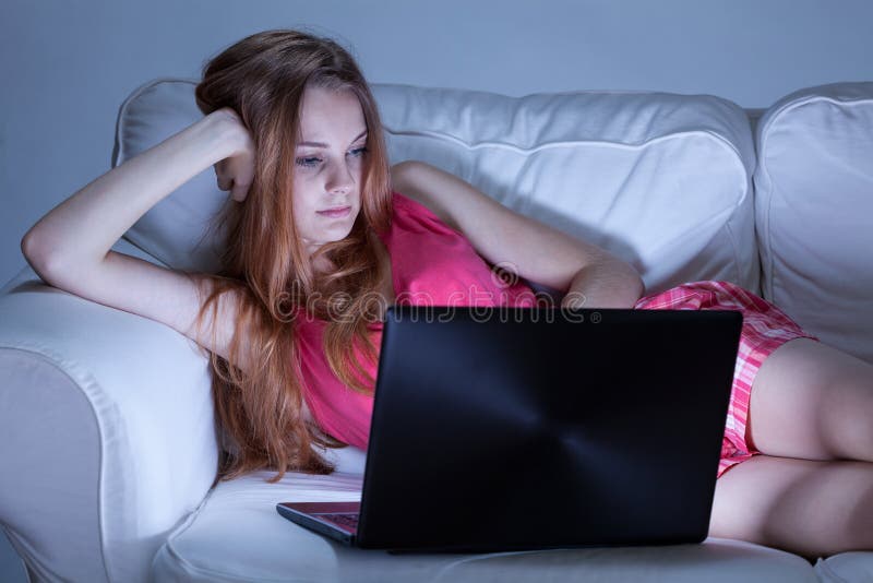 Ragazza in pigiami che scrive sui forum immagine stock libera da diritti Ragazza in pigiami che scrive sui forum immagine stock libera da diritti