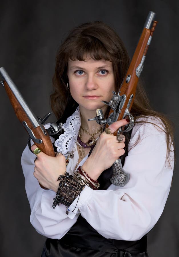 Ragazza - pirata con due pistole antiche in mani fotografia stock libera da diritti Ragazza - pirata con due pistole antiche in mani fotografia stock libera da diritti