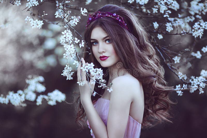 Ragazza romantica bella con capelli lunghi nell'albero di fioritura vicino del vestito rosa fotografie stock Ragazza romantica bella con capelli lunghi nell'albero di fioritura vicino del vestito rosa fotografie stock