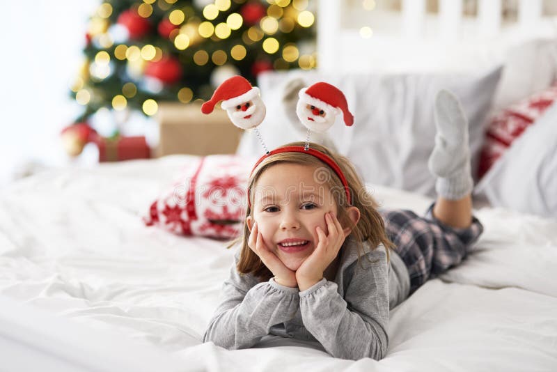 Ragazza sdraiata sul letto a Natale fotografia stock libera da diritti Ragazza sdraiata sul letto a Natale fotografia stock libera da diritti