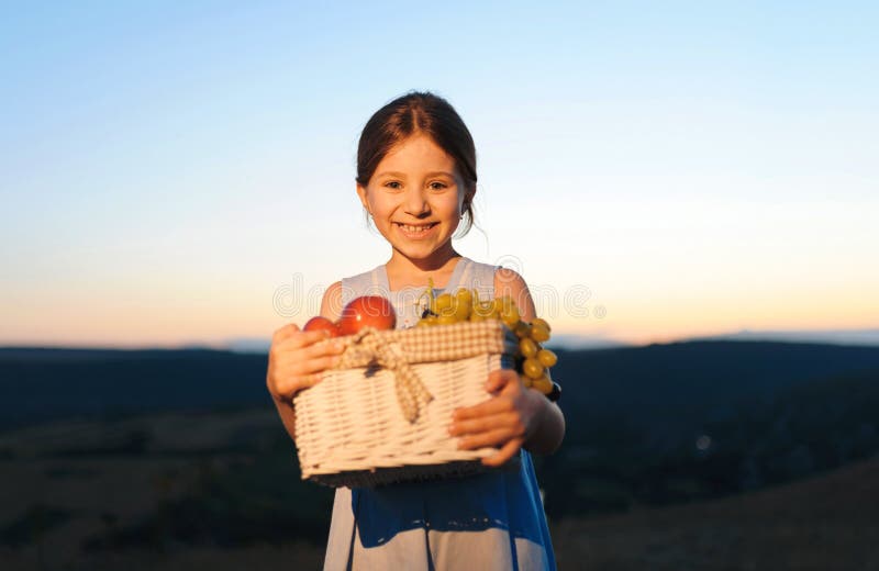 Ragazza sorridente con il cestino da picnic