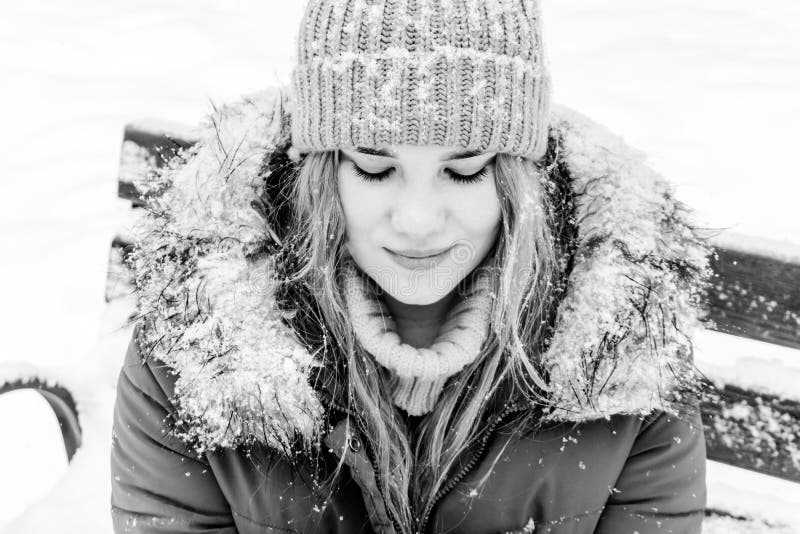 Ragazza su un banco nel parco di inverno immagini stock Ragazza su un banco nel parco di inverno immagini stock