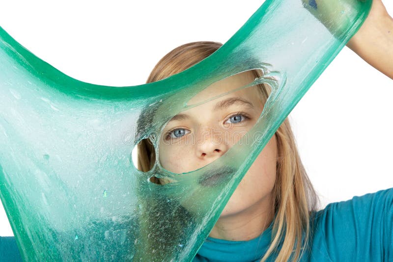 Ragazza sveglia che tiene una melma verde con un foro davanti al suo fronte immagine stock libera da diritti Ragazza sveglia che tiene una melma verde con un foro davanti al suo fronte immagine stock libera da diritti