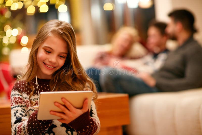 Ragazza Sveglia Con La Compressa E Le Cuffie a Casa Immagine Stock