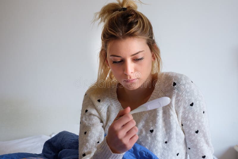 Ragazza triste che legge un risultato del test di gravidanza immagine stock Ragazza triste che legge un risultato del test di gravidanza immagine stock