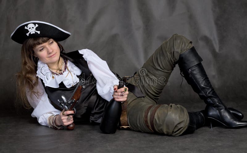 Ragazza ubriaca - pirata con la pistola e la bottiglia fotografia stock libera da diritti Ragazza ubriaca - pirata con la pistola e la bottiglia fotografia stock libera da diritti