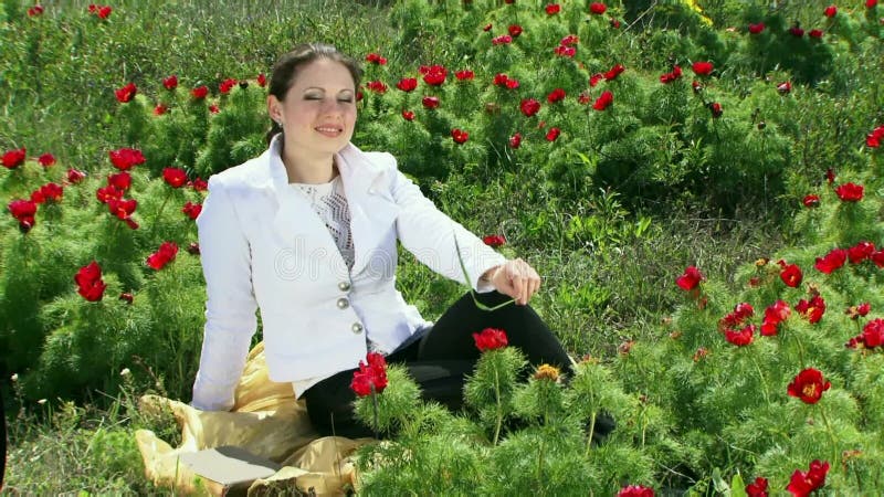 Ragazza in un campo della peonia