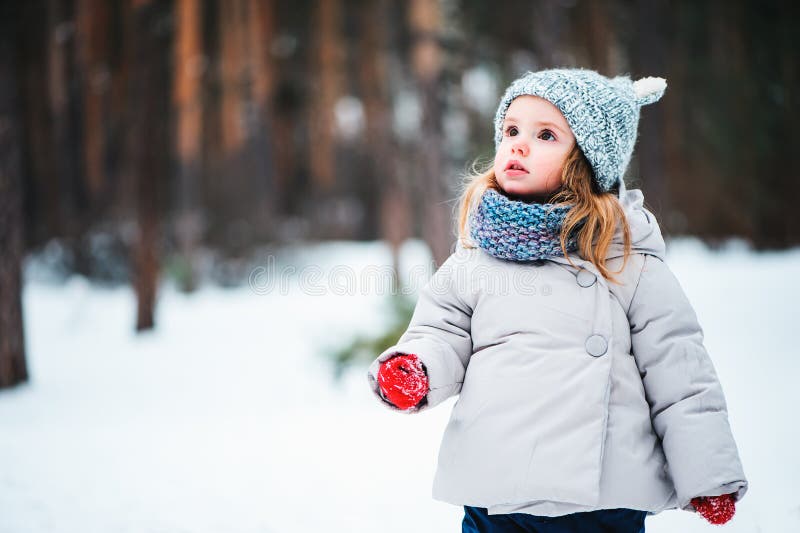 Ragazza vaga sveglia del bambino che cammina nella foresta di inverno fotografie stock Ragazza vaga sveglia del bambino che cammina nella foresta di inverno fotografie stock