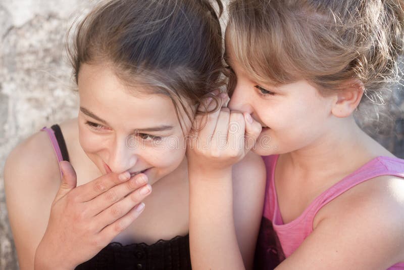 Ragazze che bisbigliano i segreti fotografia stock Ragazze che bisbigliano i segreti fotografia stock