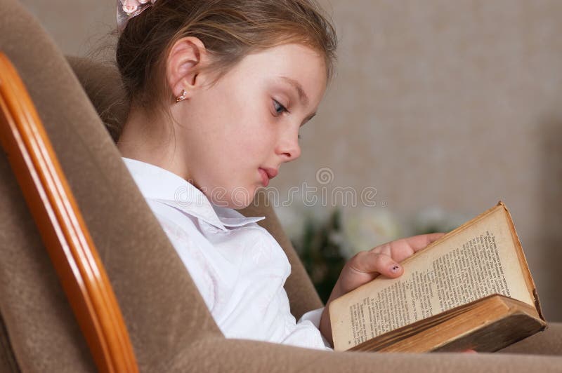 Ragazze con libro a un muro di mattoni immagine stock