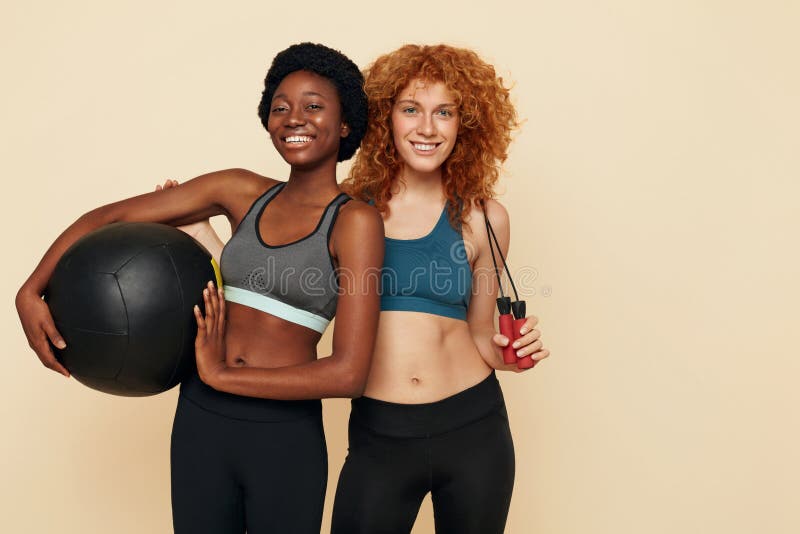 Ragazze di forma. ritratto di donne africane e caucasiche. amiche con attrezzatura per l'esercizio fisico e la telecamera. immagini stock