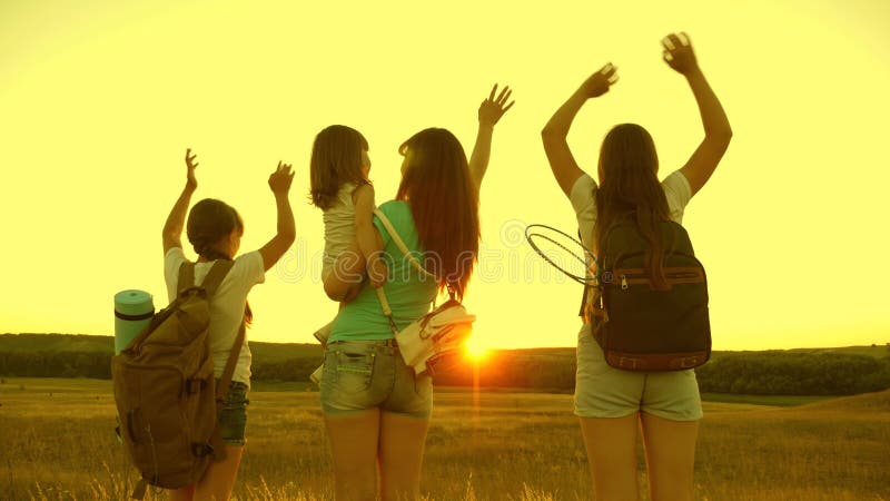 Ragazze gratis viaggiano con zainetti che agitano le mani e approfittano del tramonto. turisti sani per mamma e bambini. le ragazz video d archivio