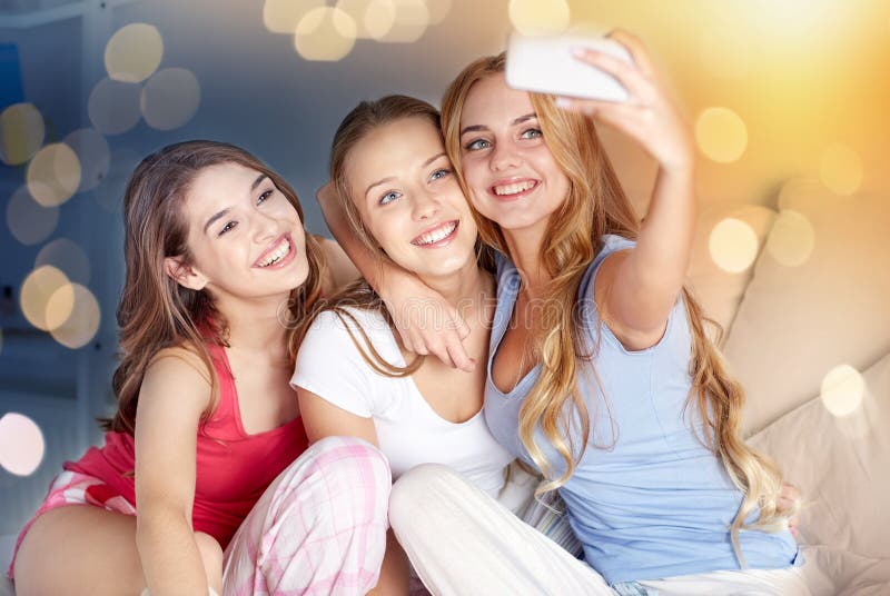 Ragazze teenager con lo smartphone che prende selfie a casa