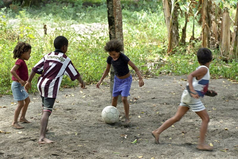 Ragazzi brasiliani e ragazze che giocano a calcio nel calore tropicale fotografie stock Ragazzi brasiliani e ragazze che giocano a calcio nel calore tropicale fotografie stock